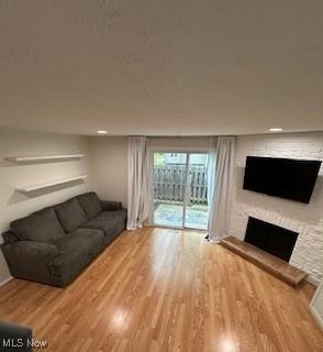 4757 Ledgewood Dr Unit 7-A, Medina, OH 44256 - living area featuring a stone fireplace and wood finished floors