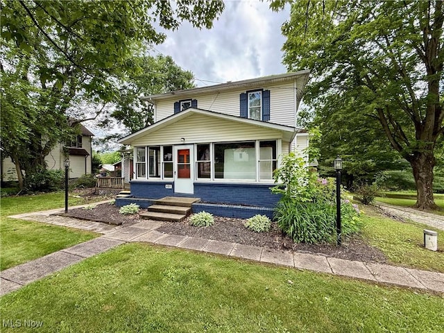 481 Steubenville Rd, Carrollton, OH 44615 - american foursquare style home with brick siding, a front yard, and a sunroom