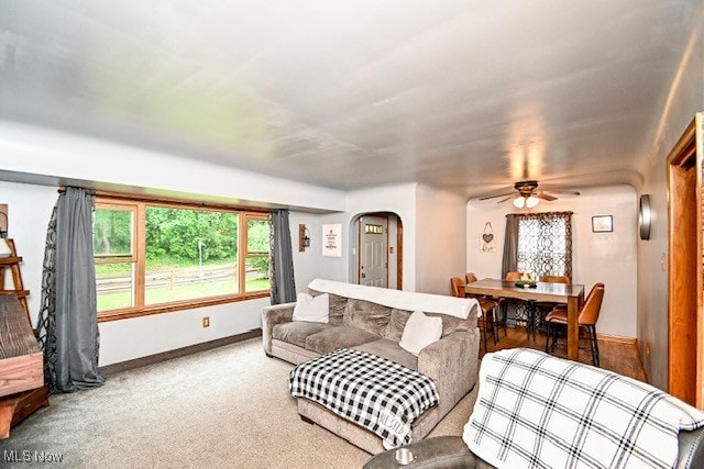 3364 Cormany Rd, Akron, OH 44319 - carpeted living room featuring arched walkways, ceiling fan, and baseboards