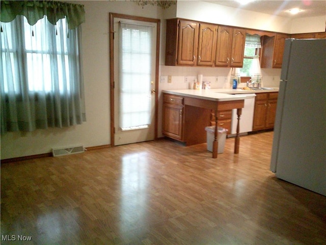 7251 Hidden Glen Dr, Amherst, OH 44001 - kitchen with white appliances, light countertops, brown cabinetry, and light wood-style floors