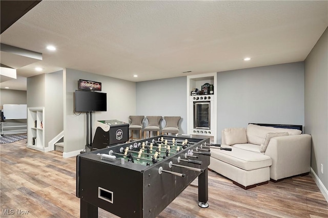 30 Harvester Dr, Copley, OH 44321 - playroom featuring light wood-type flooring, wine cooler, baseboards, recessed lighting, and a textured ceiling