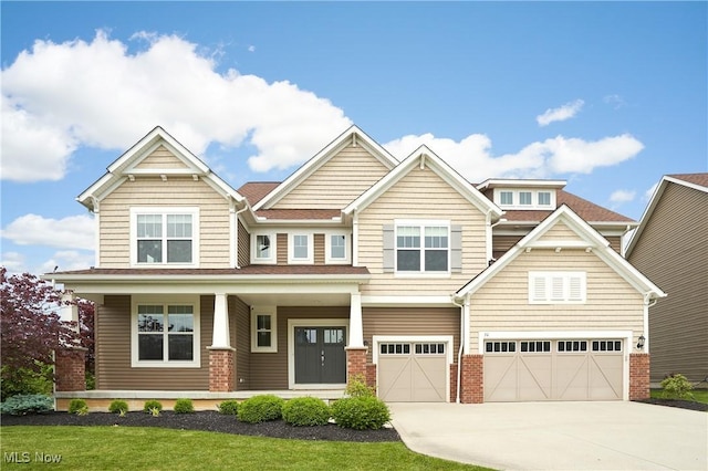 30 Harvester Dr, Copley, OH 44321 - craftsman-style house featuring concrete driveway, brick siding, an attached garage, and covered porch