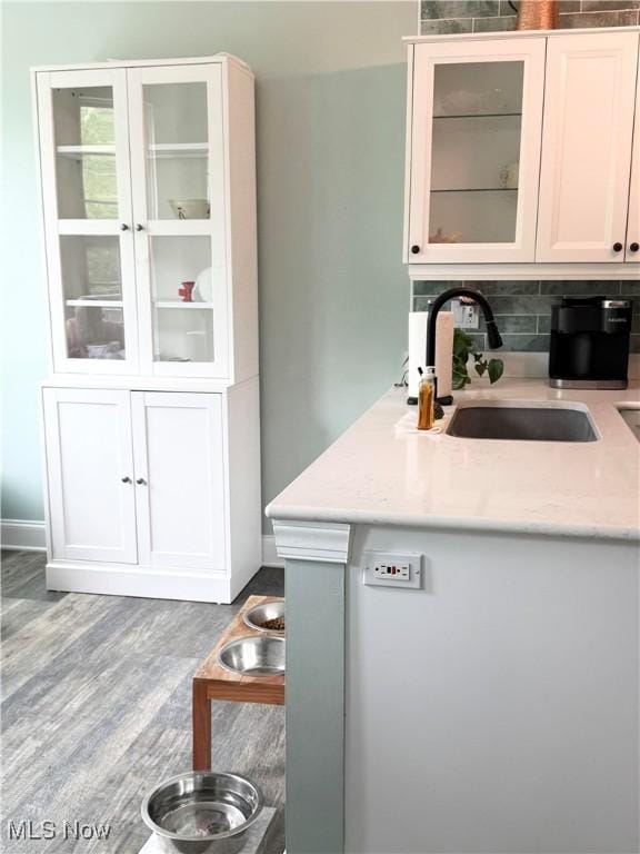 73 Falls River Dr Unit 6, Munroe Falls, OH 44262 - kitchen with a sink, decorative backsplash, wood finished floors, glass insert cabinets, and white cabinetry