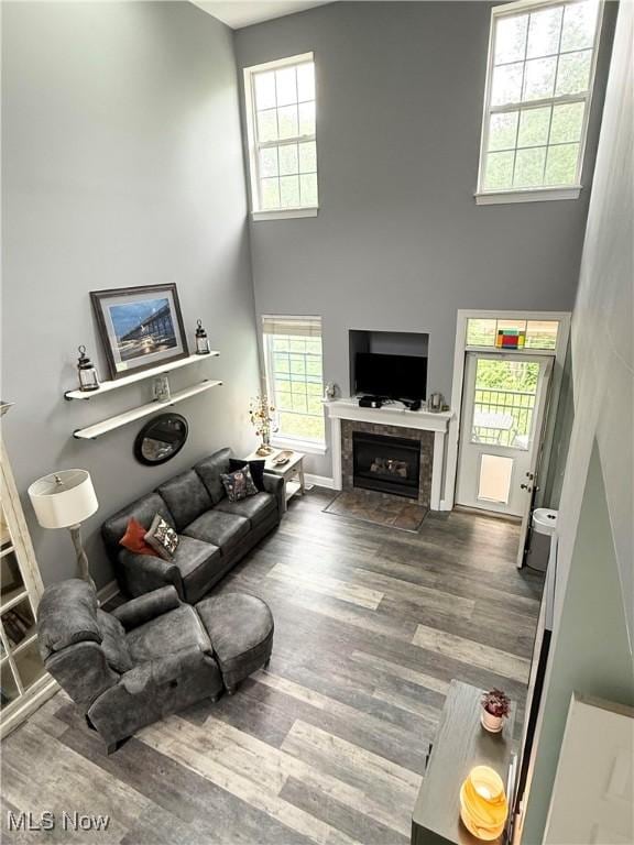 73 Falls River Dr Unit 6, Munroe Falls, OH 44262 - living area featuring a high ceiling, healthy amount of natural light, wood finished floors, a tiled fireplace, and baseboards