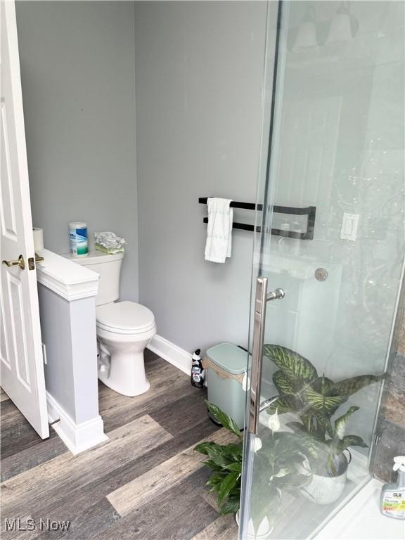 73 Falls River Dr Unit 6, Munroe Falls, OH 44262 - bathroom with a shower stall, toilet, wood finished floors, and baseboards