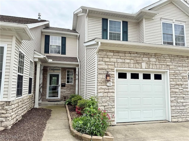 73 Falls River Dr Unit 6, Munroe Falls, OH 44262 - property entrance with stone siding, an attached garage, and driveway