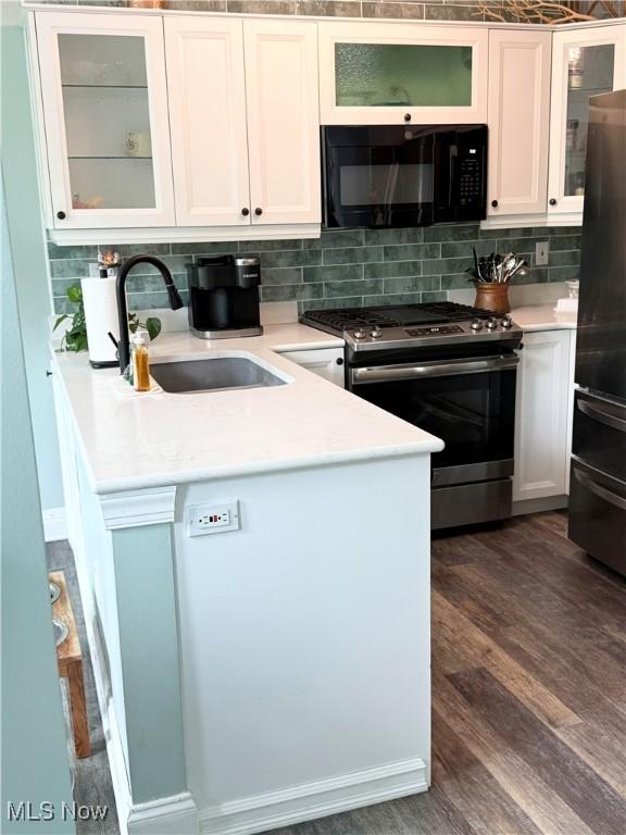 73 Falls River Dr Unit 6, Munroe Falls, OH 44262 - kitchen featuring black microwave, gas range, freestanding refrigerator, a sink, and backsplash