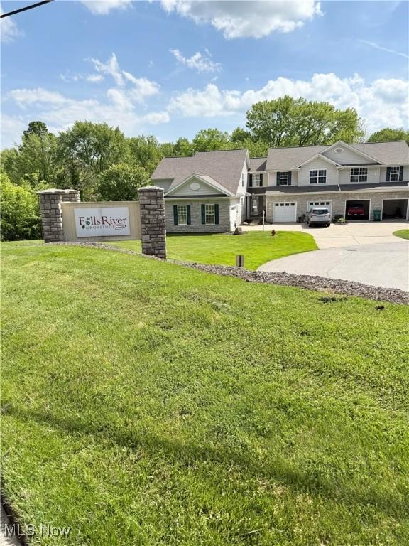 73 Falls River Dr Unit 6, Munroe Falls, OH 44262 - view of front of home featuring a front lawn, concrete driveway, stone siding, and a garage