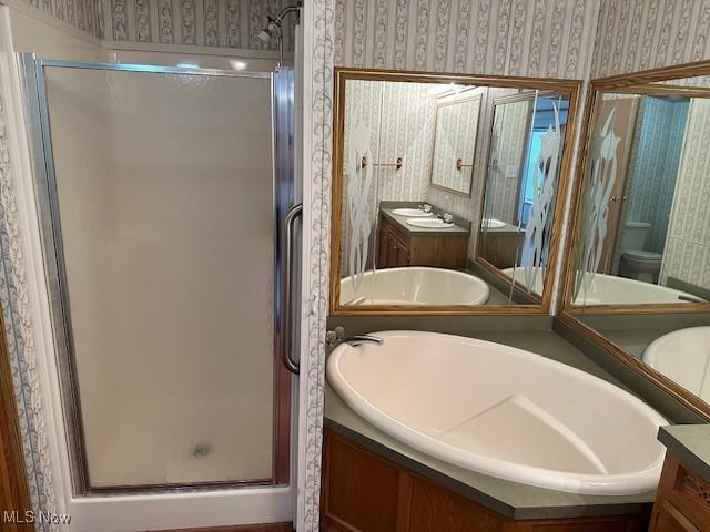 1569 Bogie Ln, Painesville, OH 44077 - full bath featuring wallpapered walls, vanity, a shower stall, toilet, and a bath