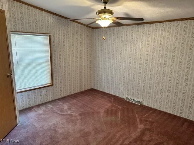 1569 Bogie Ln, Painesville, OH 44077 - empty room featuring crown molding, a ceiling fan, and carpet floors