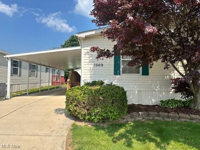 1569 Bogie Ln, Painesville, OH 44077 - view of front facade with driveway and an attached carport