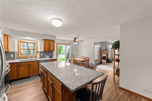 8373 Forest View Dr, Olmsted Falls, OH 44138 - kitchen featuring a sink, a breakfast bar area, brown cabinets, dishwasher, and a textured ceiling