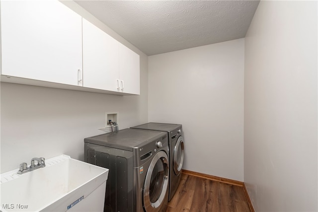 8373 Forest View Dr, Olmsted Falls, OH 44138 - laundry area with cabinet space, washing machine and dryer, wood finished floors, baseboards, and a textured ceiling