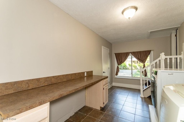 8526 Hoyt Ct, Mentor, OH 44060 - washroom featuring a textured ceiling, dark tile patterned flooring, washer / dryer, a desk, and baseboards
