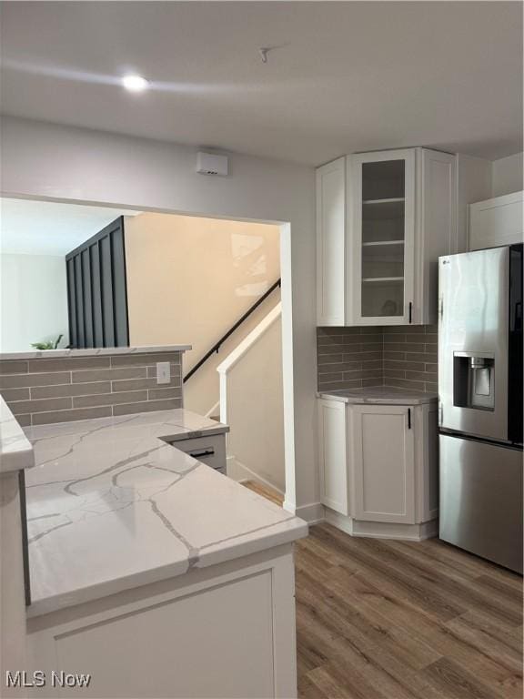 1267 Worton Blvd, Mayfield Heights, OH 44124 - kitchen featuring stainless steel refrigerator with ice dispenser, white cabinets, wood finished floors, glass insert cabinets, and backsplash