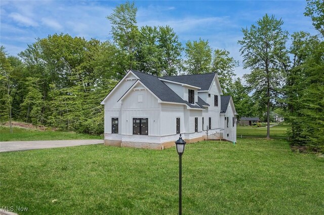 810 Club Dr W, Aurora, OH 44202 - view of property exterior featuring a lawn, board and batten siding, and roof with shingles