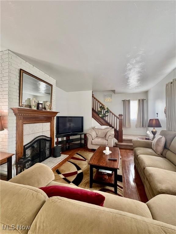 9 Poplar St, Bridgeport, OH 43912 - living area featuring hardwood / wood-style flooring, stairway, a tile fireplace, and baseboards