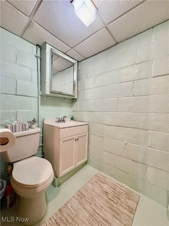 9 Poplar St, Bridgeport, OH 43912 - bathroom with vanity, concrete floors, toilet, and a drop ceiling
