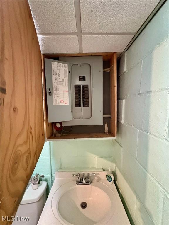 9 Poplar St, Bridgeport, OH 43912 - bathroom with electric panel, concrete block wall, vanity, and toilet