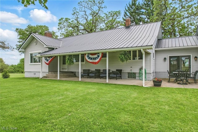 10626 Oakview Dr, Beloit, OH 44609 - back of property with a chimney, a standing seam roof, a lawn, a patio area, and metal roof