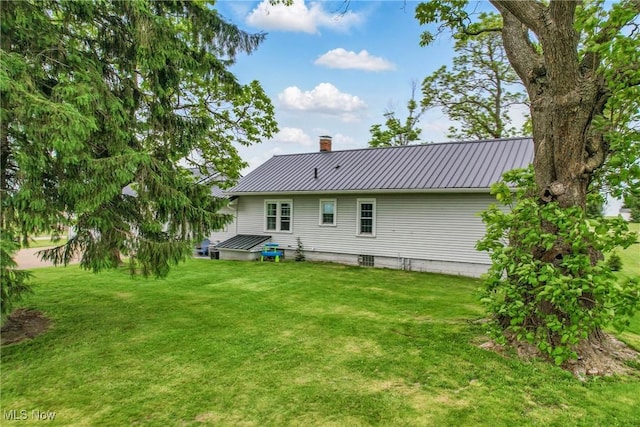 10626 Oakview Dr, Beloit, OH 44609 - back of house featuring a chimney, metal roof, and a yard