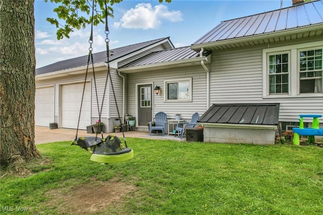 10626 Oakview Dr, Beloit, OH 44609 - rear view of property featuring a standing seam roof, a garage, concrete driveway, metal roof, and a lawn
