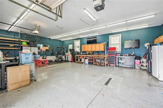 10626 Oakview Dr, Beloit, OH 44609 - garage with a workshop area, a garage door opener, and freestanding refrigerator