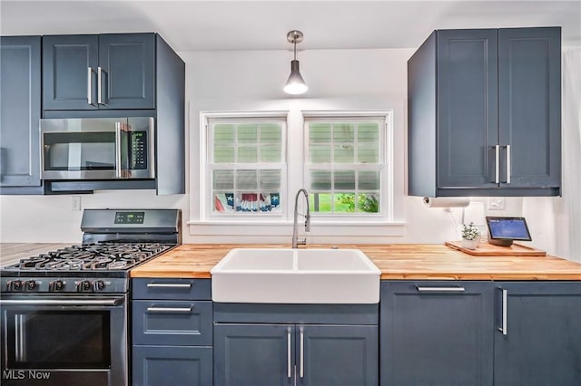 10626 Oakview Dr, Beloit, OH 44609 - kitchen with stainless steel microwave, gas range, wood counters, a sink, and healthy amount of natural light