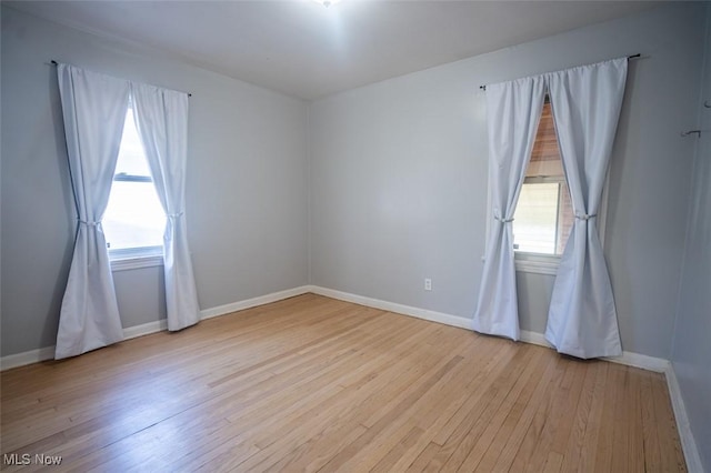 7811 Snow Rd, Parma, OH 44129 - empty room with hardwood / wood-style floors, healthy amount of natural light, and baseboards