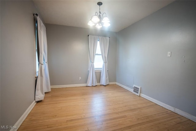 7811 Snow Rd, Parma, OH 44129 - empty room featuring a chandelier, light wood-style floors, and baseboards