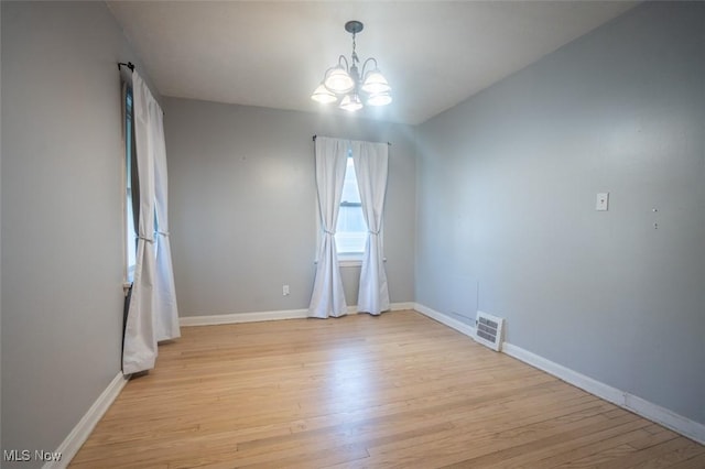 7811 Snow Rd, Parma, OH 44129 - empty room with a chandelier, light wood-style floors, and baseboards