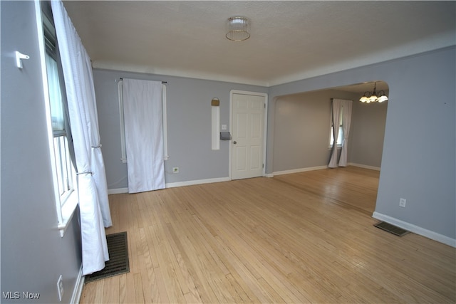 7811 Snow Rd, Parma, OH 44129 - empty room featuring light wood finished floors, a chandelier, and baseboards