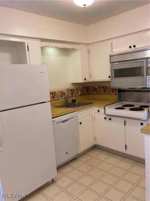 3 Meadowlawn Dr Unit 14, Mentor, OH 44060 - kitchen with white appliances, a sink, white cabinetry, light flooring, and light countertops