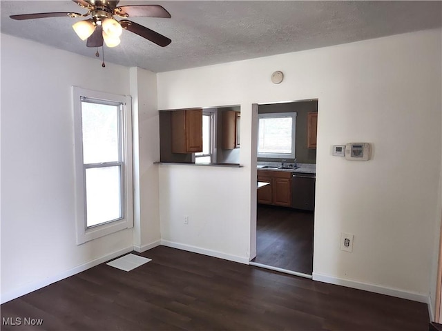 681 Madison St, Conneaut, OH 44030 - unfurnished dining area with a ceiling fan, dark wood-type flooring, a textured ceiling, a sink, and baseboards