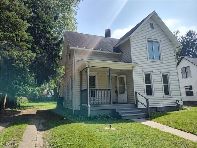 681 Madison St, Conneaut, OH 44030 - traditional-style home featuring covered porch, a front yard, and a chimney