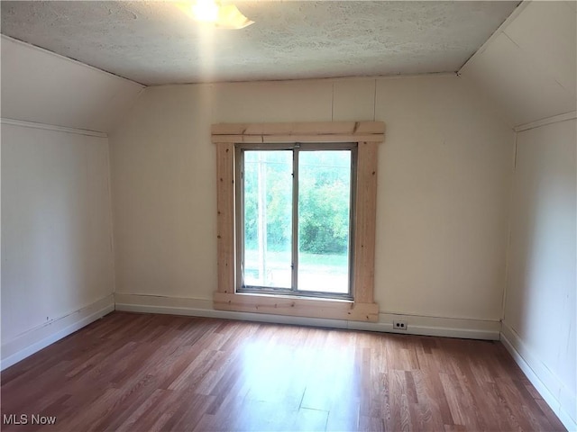 681 Madison St, Conneaut, OH 44030 - unfurnished room featuring wood finished floors, vaulted ceiling, a textured ceiling, and baseboards