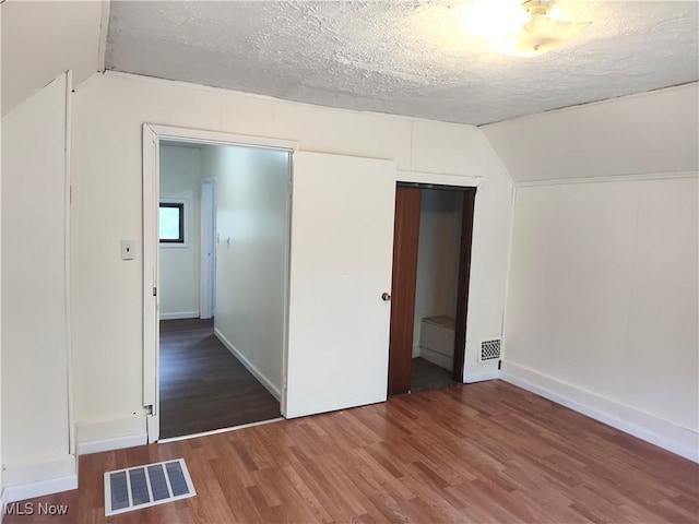 681 Madison St, Conneaut, OH 44030 - unfurnished bedroom with vaulted ceiling, wood finished floors, a textured ceiling, baseboards, and a closet