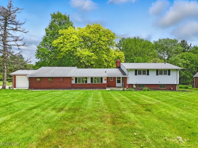 8049 Mccreary Rd, Broadview Heights, OH 44147 - split level home with a front lawn, a garage, a chimney, brick siding, and view of wooded area