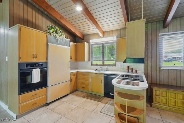 8049 Mccreary Rd, Broadview Heights, OH 44147 - kitchen featuring black oven, paneled built in fridge, dishwashing machine, light countertops, and wooden walls