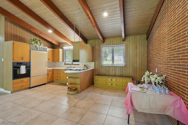 8049 Mccreary Rd, Broadview Heights, OH 44147 - kitchen featuring black oven, paneled refrigerator, light countertops, brick wall, and a peninsula