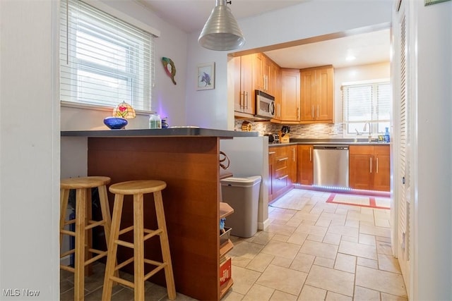 168 Brooklyn Ave, Salem, OH 44460 - kitchen with stainless steel appliances, backsplash, a kitchen bar, a sink, and a peninsula
