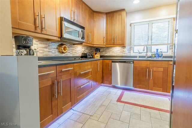 168 Brooklyn Ave, Salem, OH 44460 - kitchen with appliances with stainless steel finishes, a sink, tasteful backsplash, brown cabinets, and recessed lighting