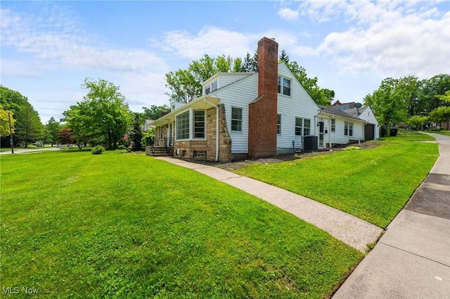 1572 S Belvoir Blvd, South Euclid, OH 44121 - view of side of home with a chimney, a yard, stone siding, and central air condition unit
