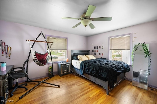 1572 S Belvoir Blvd, South Euclid, OH 44121 - bedroom with multiple windows, light wood-style floors, and a ceiling fan