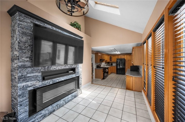 1572 S Belvoir Blvd, South Euclid, OH 44121 - kitchen with black appliances, a fireplace, brown cabinets, lofted ceiling, and light tile patterned flooring