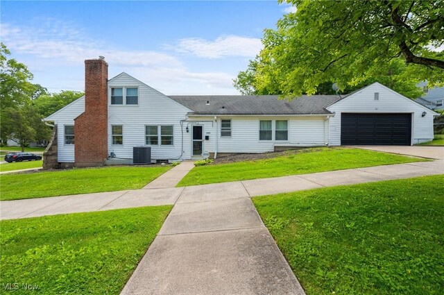 1572 S Belvoir Blvd, South Euclid, OH 44121 - view of front facade featuring a front yard, a chimney, concrete driveway, an attached garage, and central AC