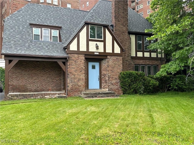 13707 Drexmore Rd, Shaker Heights, OH 44120 - english style home featuring a shingled roof, brick siding, a front lawn, and a chimney