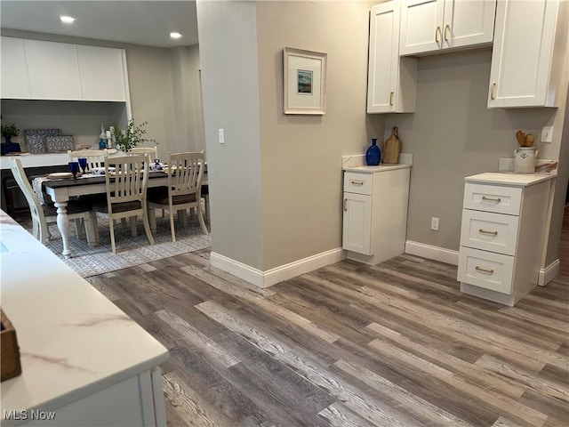 13707 Drexmore Rd, Shaker Heights, OH 44120 - kitchen with wood finished floors, recessed lighting, white cabinetry, baseboards, and light stone countertops