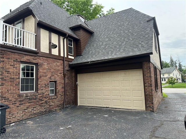 13707 Drexmore Rd, Shaker Heights, OH 44120 - view of side of property with asphalt driveway, roof with shingles, brick siding, and an attached garage
