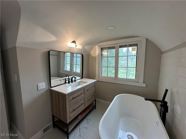 13707 Drexmore Rd, Shaker Heights, OH 44120 - bathroom featuring vanity, a freestanding tub, baseboards, marble finish flooring, and vaulted ceiling